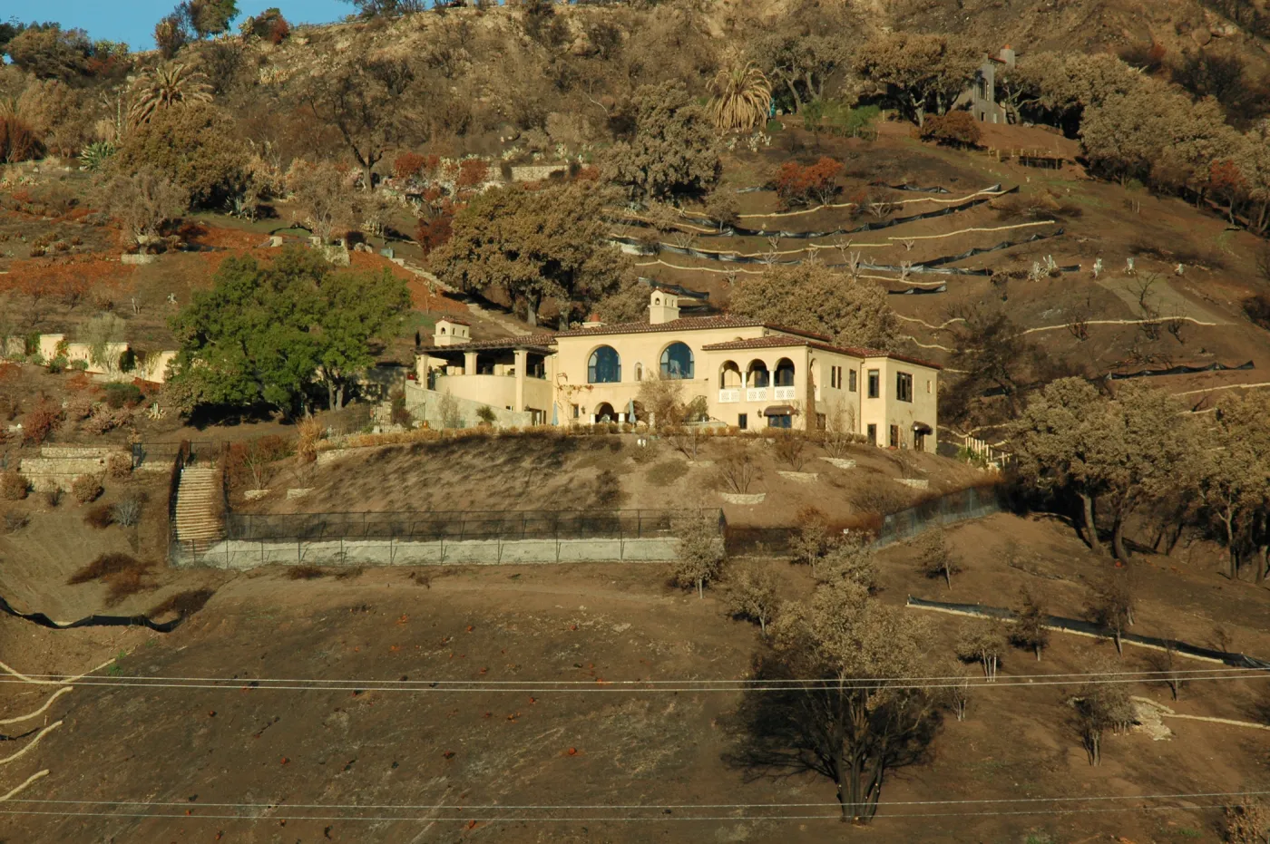 Tea Fire, Mountain Drive, unburned home, fire scape. Note singed and unsinged oaks, chaparral stumps on lower slope.