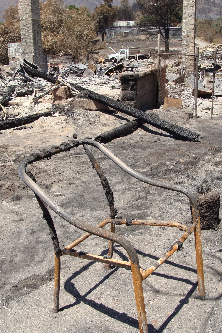 burned chair frame and debris, after the Jesusita Fire