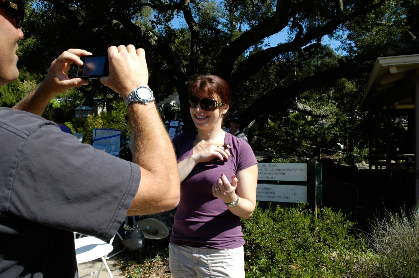 visitor holding a monarch butterfly, Master Gardener butterfly demonstration table, SBBG Community Free Day, October 16 2011