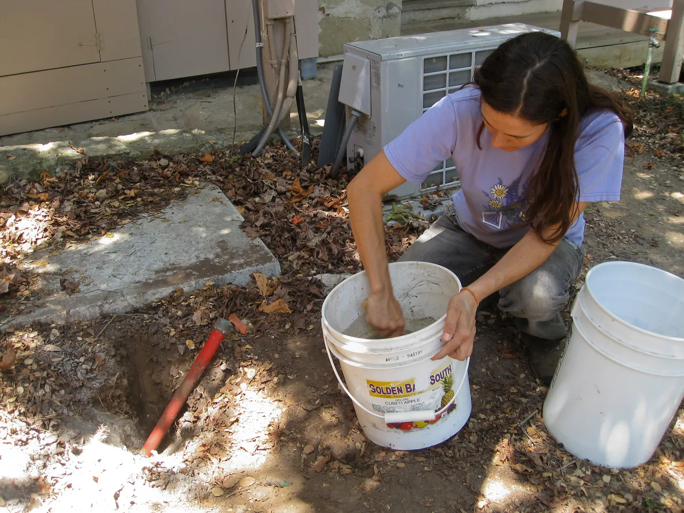 Betsy Lape setting new grid marker in concrete