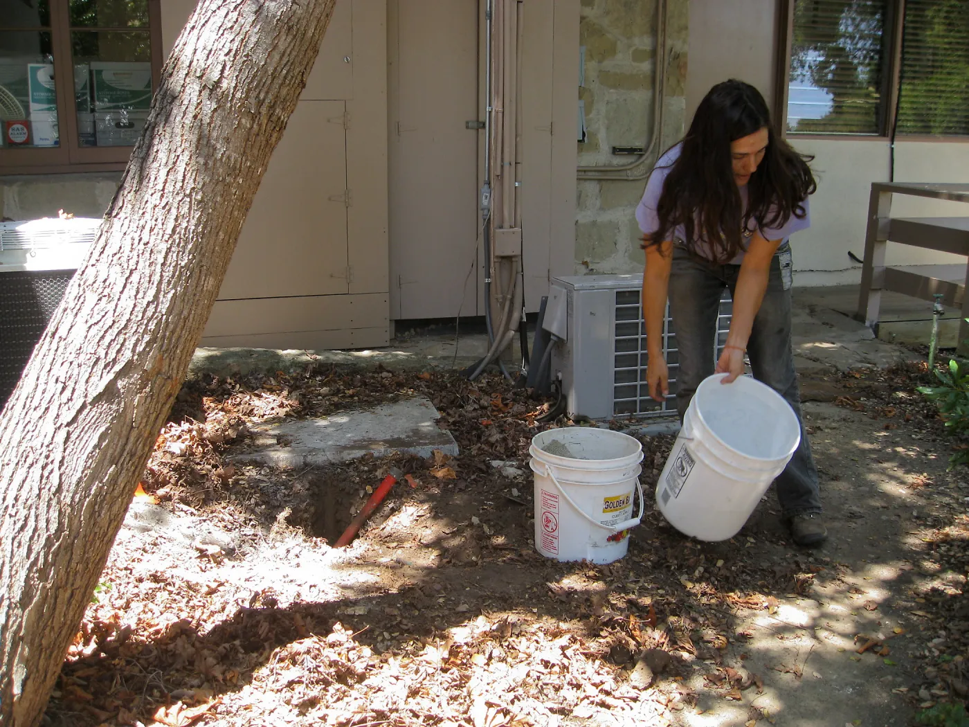 Betsy Lape setting new grid marker in concrete