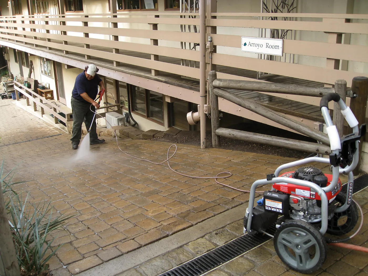 Jim Lechuga powerwashing walkway east side of North Wing