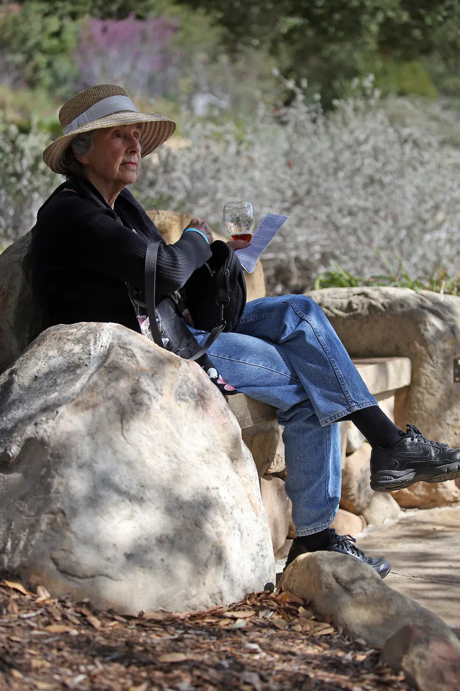Santa Barbara Beer Garden Event, visitor seated on stone bench in the garden