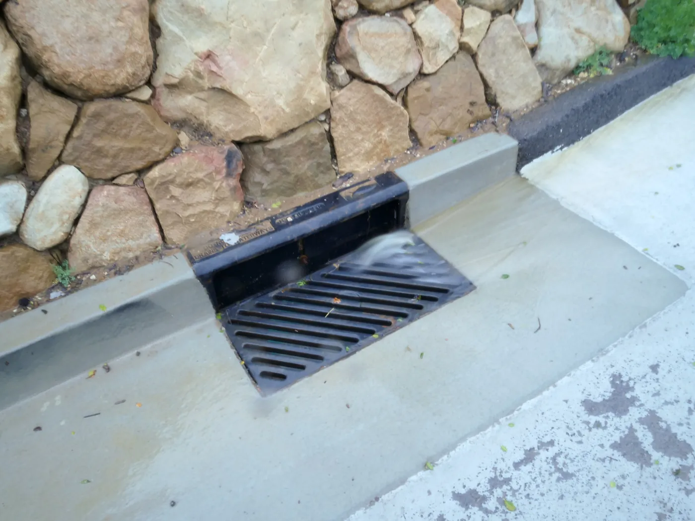 Rainwater entering a storm drain leading to the Pritzlaff Conservation Center bioswale