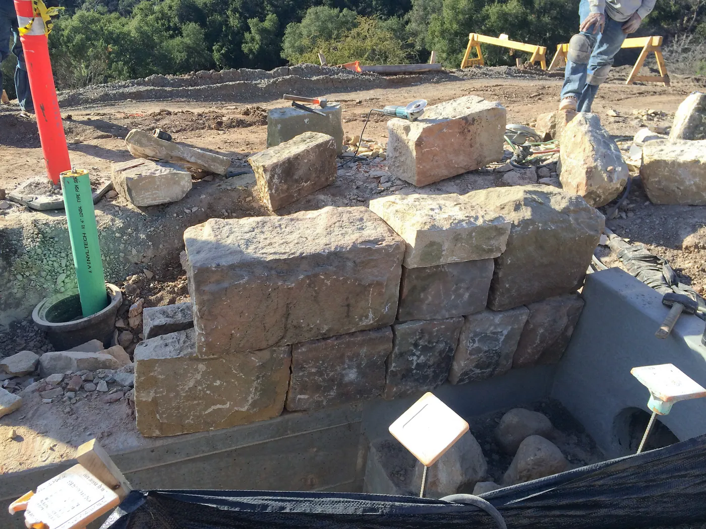 Construction of back wall of rill at Pritzlaff Conservation Center using cut stone from Gane house foundation