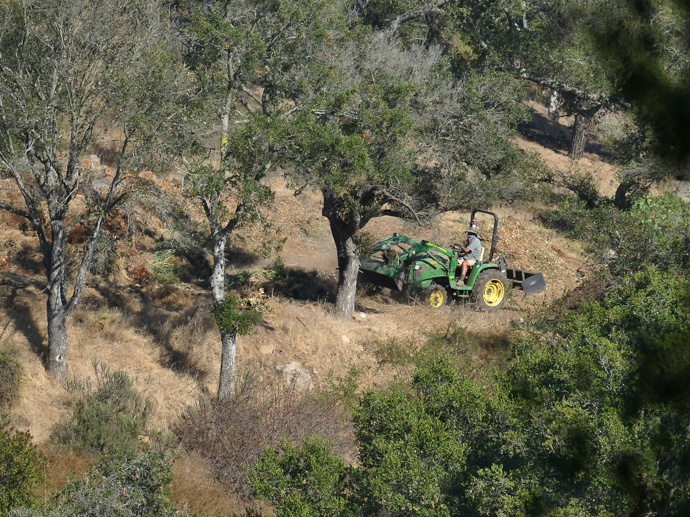 Tony Lee building compost pile with tractor