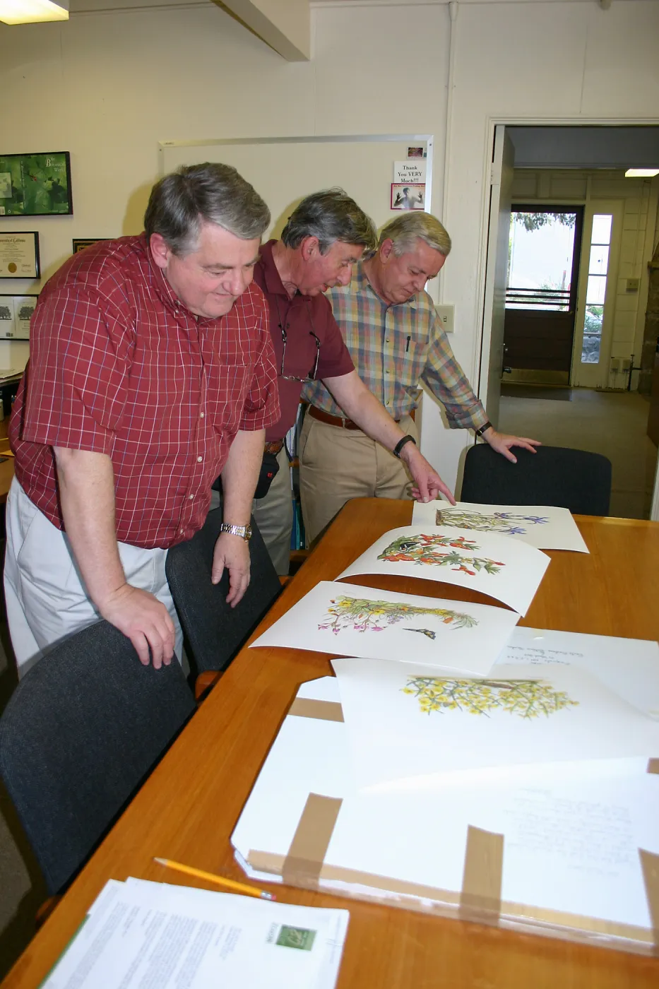 Ed Schneider, Patick O'Hara, and Bob Sherwood viewing artwork