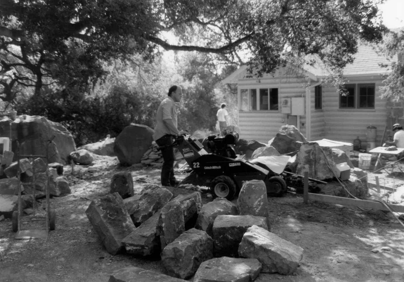 Construction crew at work in front of Cottage. Patio and rock wall construction - Home Demonstration Garden
