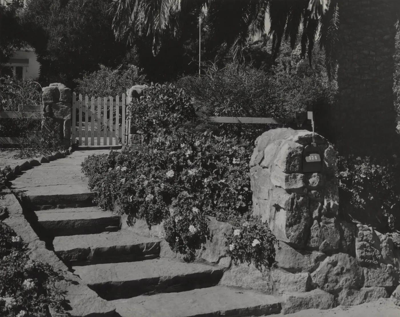Mailbox set into sturdy stone structure that blends into wall & steps, Hope Ranch home