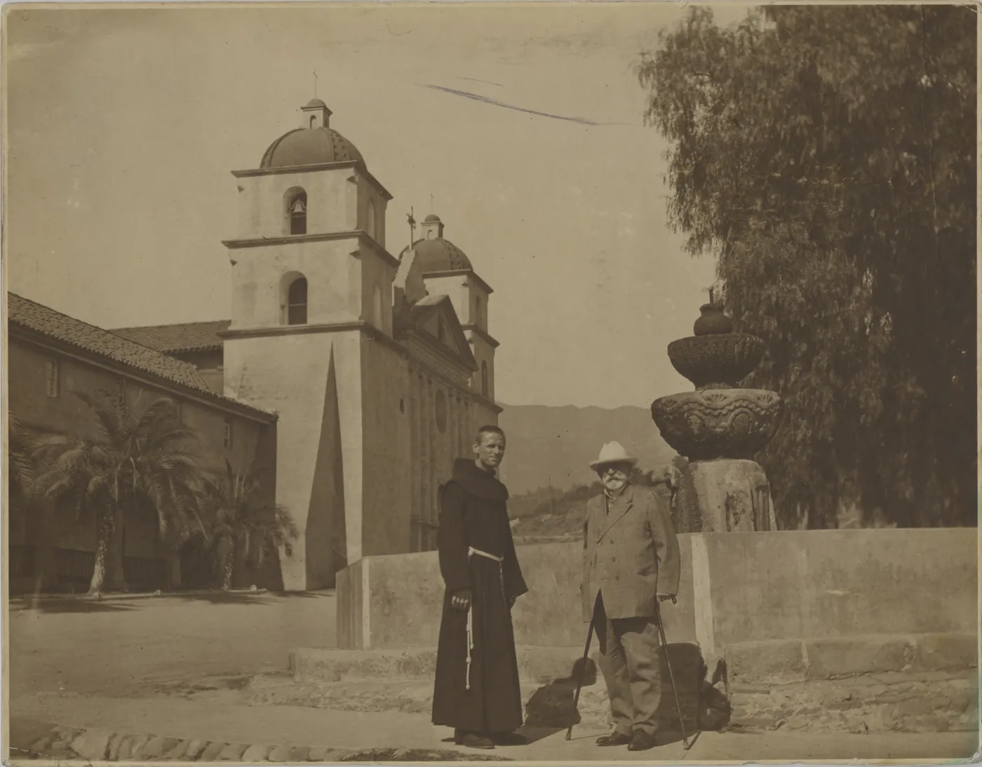 E.O. Orpet with Franciscan in front of Mission