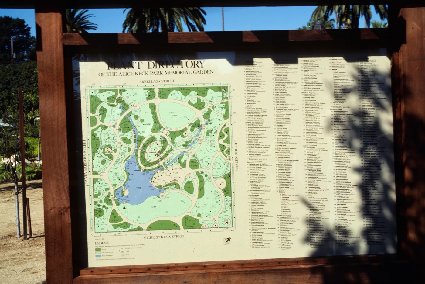 An outdoor map and lengthy directory in a wooden frame titled "Plant Directory of the Alice Keck Park Memorial Garden." 