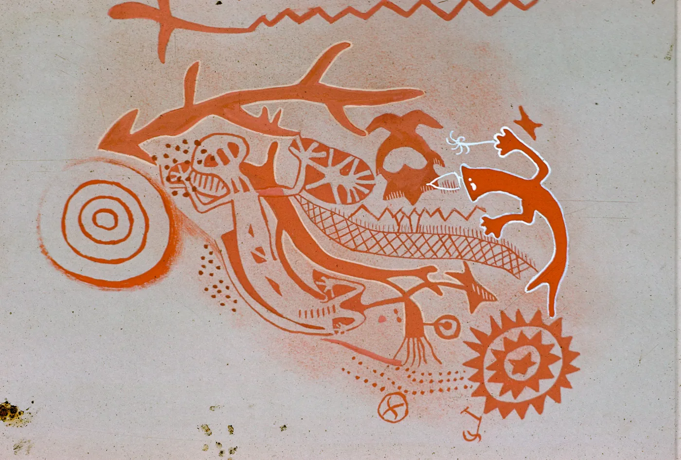 An orange pictograph beaturing concentric circles, zig-zagging lines, and lizard-like figures on a white background.