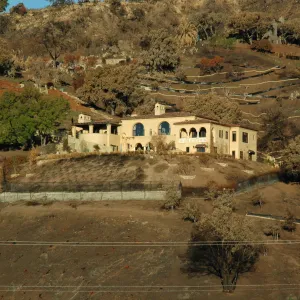 Tea Fire, Mountain Drive, unburned home, fire scape. Note singed and unsinged oaks, chaparral stumps on lower slope.