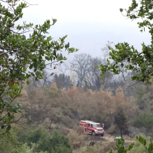 Fire truck parked below the burned remains of the Gane House, after the Jesusita Fire