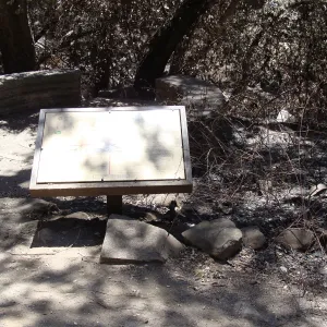 Fiber Arts Display sign, with spiral patio and circular stone bench, after the Jesusita Fire