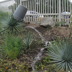 Broken irrigation pipe on parking lot bank