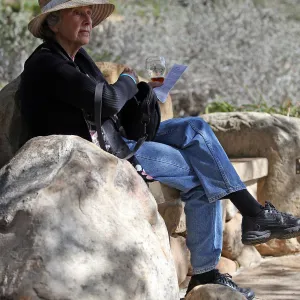 Santa Barbara Beer Garden Event, visitor seated on stone bench in the garden