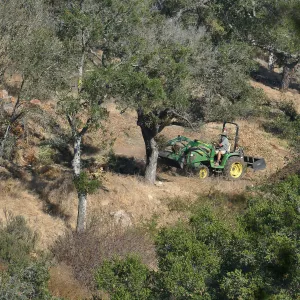 Tony Lee building compost pile with tractor