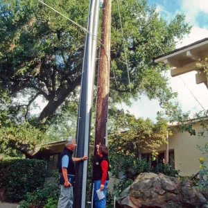 New power pole installed adjacent to the old wooden 'acorn granary' pole
