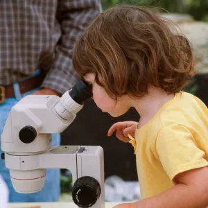 Child looking into microscope